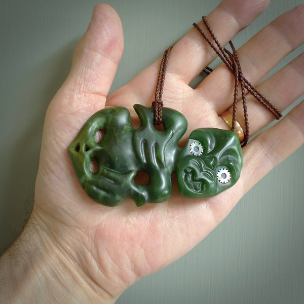 This is a large sized tiki - carved from gorgeous Marsden jade with Pāua Shell eyes. The craftsmanship is superb, this piece is as well carved as any we have seen. We have plaited an adjustable brown cord for this piece. 