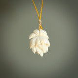 This is a hand carved lotus flower pendant. It is made from bone. This is a medium sized necklace and is a very unique, pendant that is a collectors piece. Hand carved bone lotus flower necklace.
