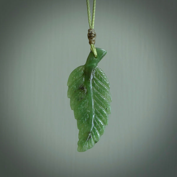 A delicate green jade fern leaf pendant with an adjustable neck cord. Green stone fern leaf necklace with adjustable cord. Delivery included.
