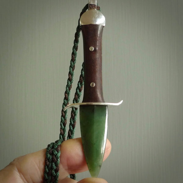 A striking hand carved knife pendant that we've called the blade. These are carved with a jade head and a hardwood handle. The cords are hand plaited in our waxed polyester which is robust, strong and durable. We ship these worldwide with express courier.
