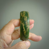 Hand carved jade bangle. Carved from green New Zealand jade. This is a solid jade bangle carved from a single piece of jade. It is polished to a sleek matte. the jade is otherwise untreated and completely natural.
