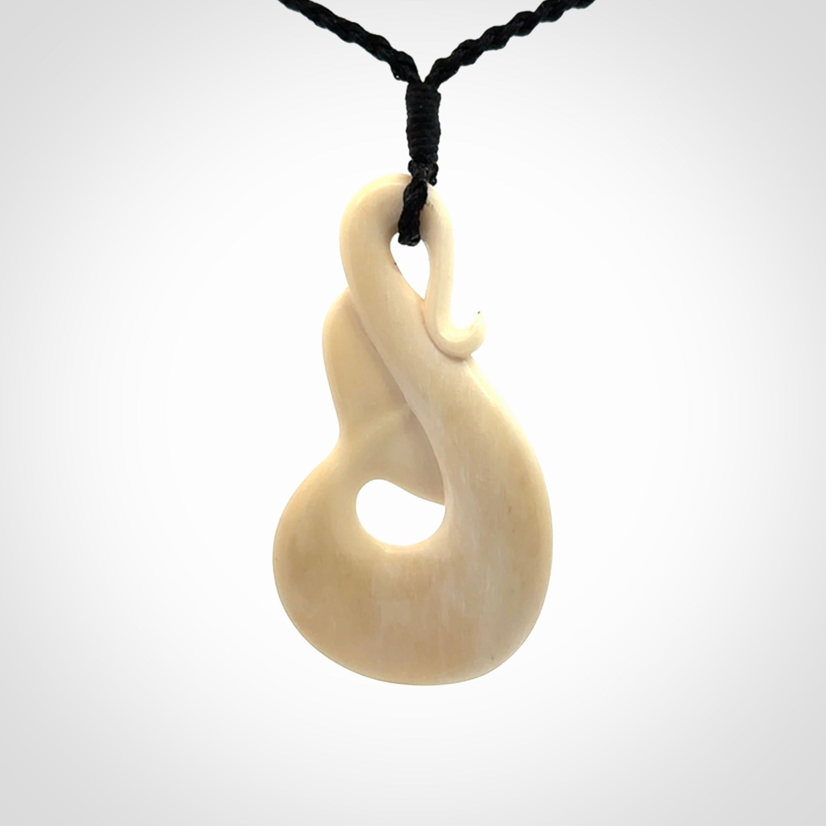 Hand carved Bone Whale Tail pendant by Andrew Doughty. Whale tail pendant by Andrew Doughty with engraving in it. Beautiful unisex necklace hand carved in New Zealand, delivered in a woven kete pouch. Provided with an adjustable beige cord.
