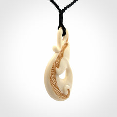 Hand carved Bone Whale Tail pendant by Andrew Doughty. Whale tail pendant by Andrew Doughty with engraving in it. Beautiful unisex necklace hand carved in New Zealand, delivered in a woven kete pouch. Provided with an adjustable beige cord.