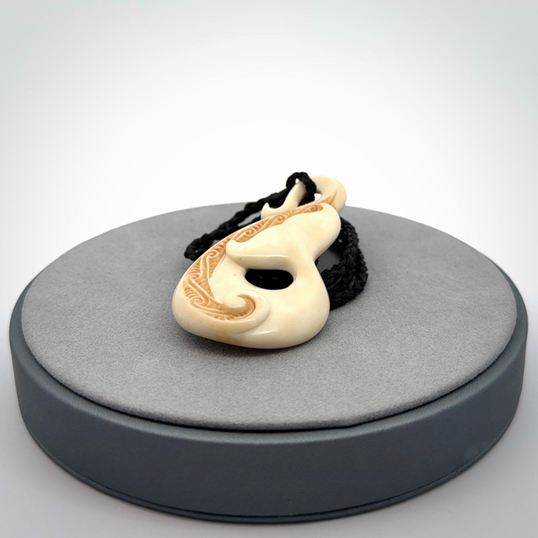 Hand carved Bone Whale Tail pendant by Andrew Doughty. Whale tail pendant by Andrew Doughty with engraving in it. Beautiful unisex necklace hand carved in New Zealand, delivered in a woven kete pouch. Provided with an adjustable beige cord.