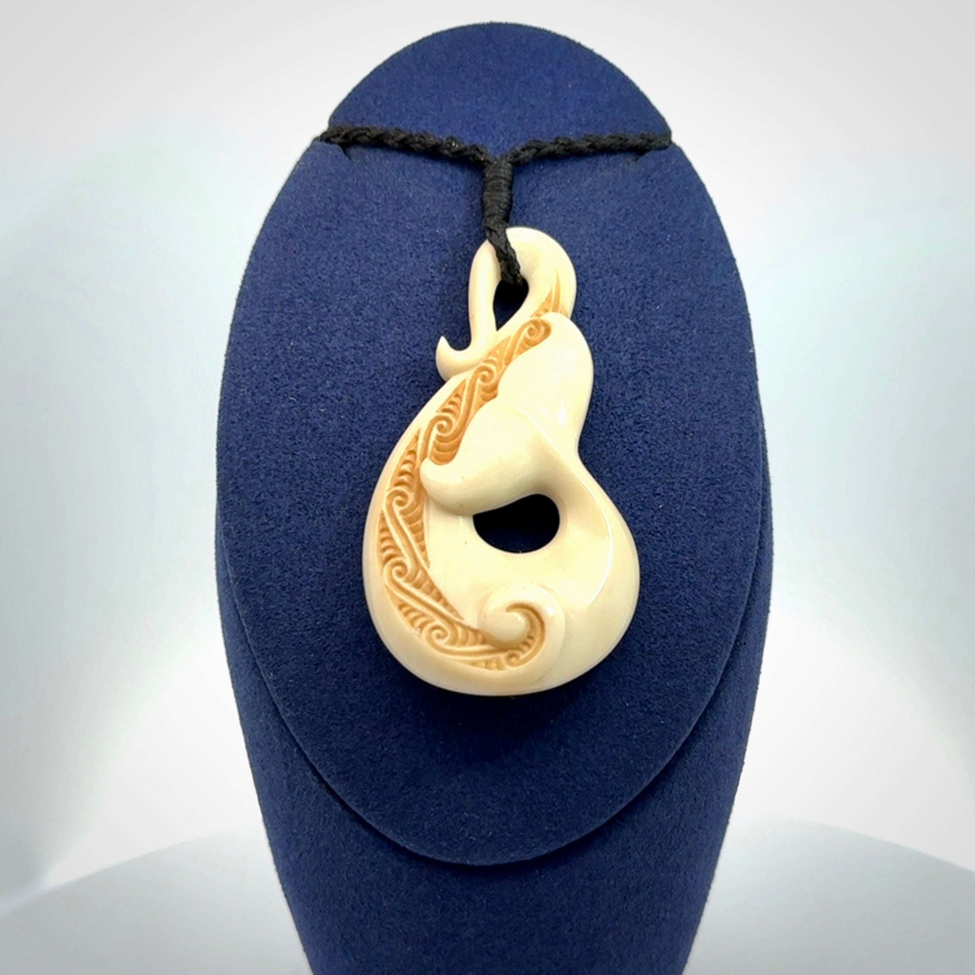 Hand carved Bone Whale Tail pendant by Andrew Doughty. Whale tail pendant by Andrew Doughty with engraving in it. Beautiful unisex necklace hand carved in New Zealand, delivered in a woven kete pouch. Provided with an adjustable beige cord.