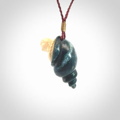 This photo shows a Buddha pendant hand carved in Woolly Mammoth Tusk with Moss Agate. It is provided with an adjustable plum cord.