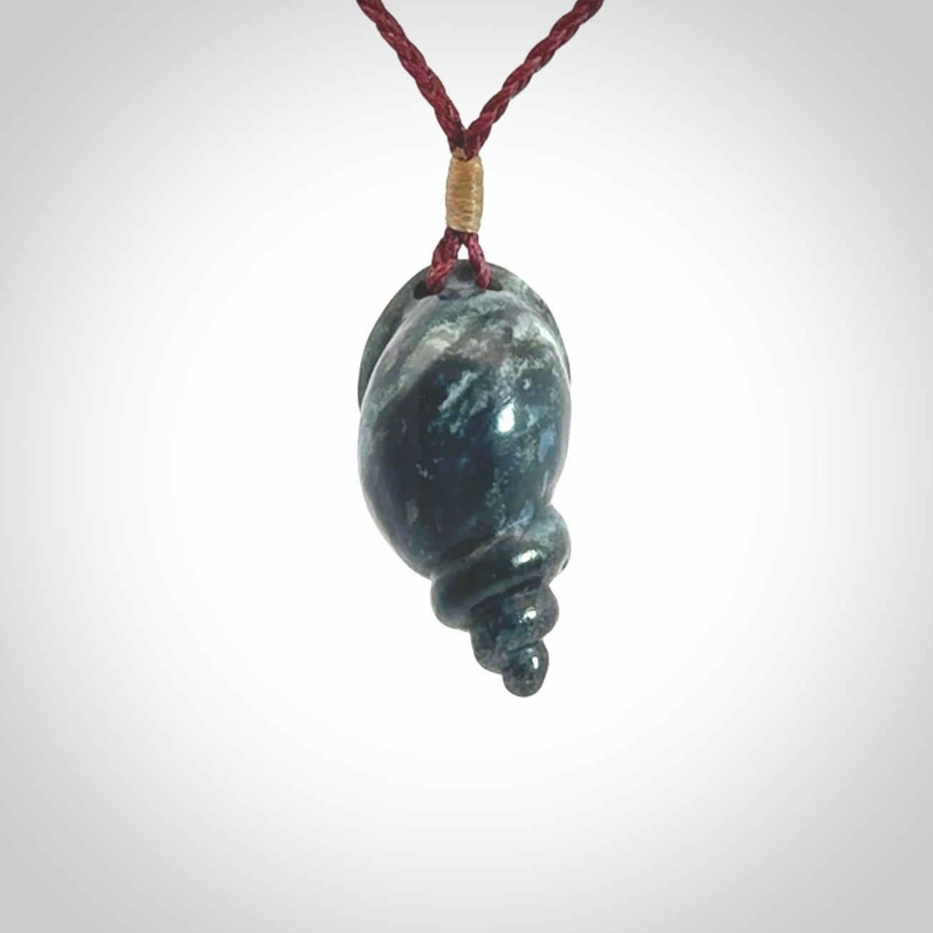 This photo shows a Buddha pendant hand carved in Woolly Mammoth Tusk with Moss Agate. It is provided with an adjustable plum cord.