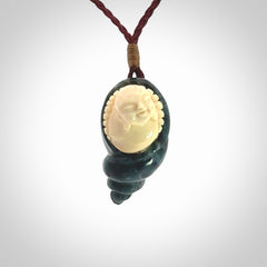 This photo shows a Buddha pendant hand carved in Woolly Mammoth Tusk with Moss Agate. It is provided with an adjustable plum cord.