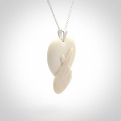 This is a hand carved love heart with love fingers made from bone with sterling silver bale and provided with a sterling silver chain.