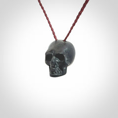 This picture shows a small Black Obsidian stone skull pendant that we have hand carved. It is polished to a soft shine and is a very striking piece. Provided with an adjustable plum cord.