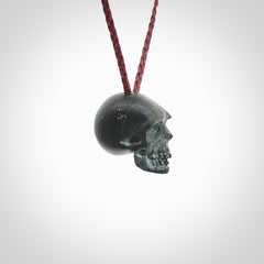 This picture shows a small Black Obsidian stone skull pendant that we have hand carved. It is polished to a soft shine and is a very striking piece. Provided with an adjustable plum cord.