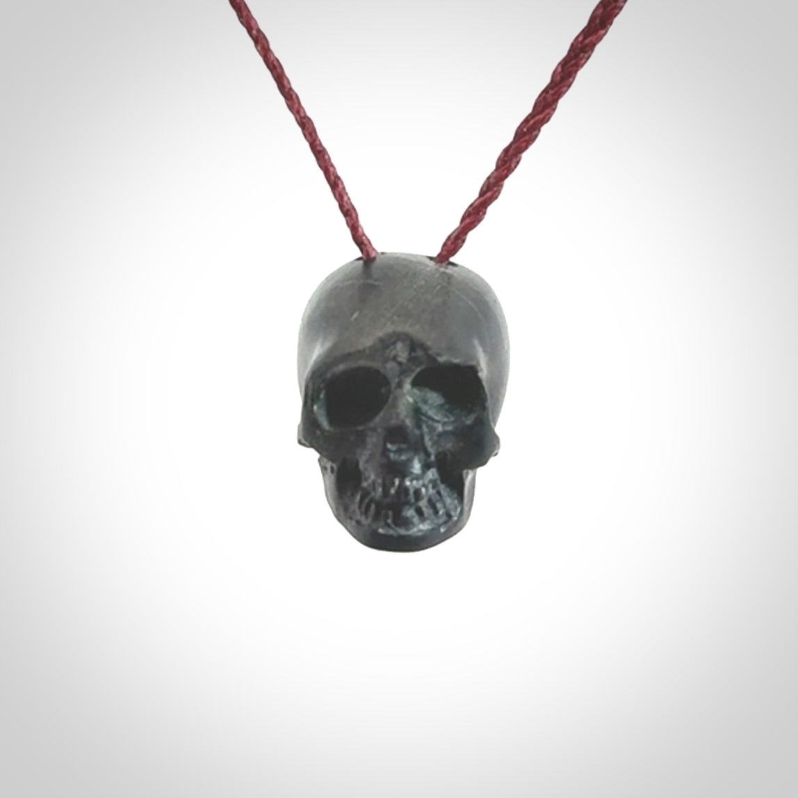 This picture shows a small Black Obsidian stone skull pendant that we have hand carved. It is polished to a soft shine and is a very striking piece. Provided with an adjustable plum cord.