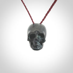 This picture shows a small Black Obsidian stone skull pendant that we have hand carved. It is polished to a soft shine and is a very striking piece. Provided with an adjustable plum cord.
