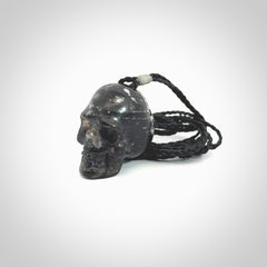 This picture shows a medium sized Snowflake Obsidian stone skull pendant that we have hand carved. It is polished to a soft shine and is a very striking piece. Provided with an adjustable black cord.