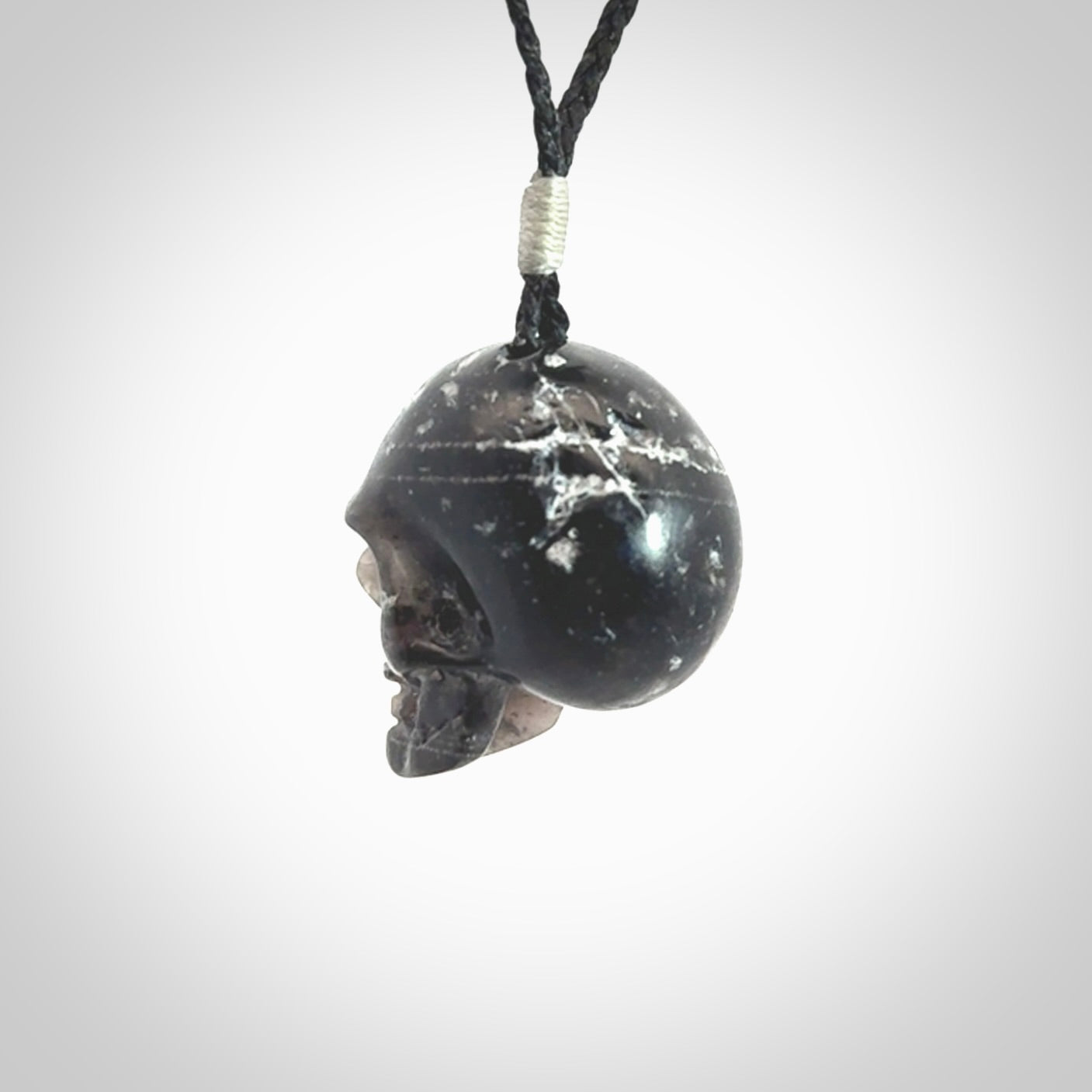 This picture shows a medium sized Snowflake Obsidian stone skull pendant that we have hand carved. It is polished to a soft shine and is a very striking piece. Provided with an adjustable black cord.