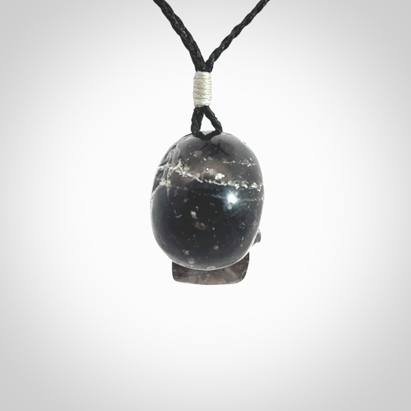This picture shows a medium sized Snowflake Obsidian stone skull pendant that we have hand carved. It is polished to a soft shine and is a very striking piece. Provided with an adjustable black cord.