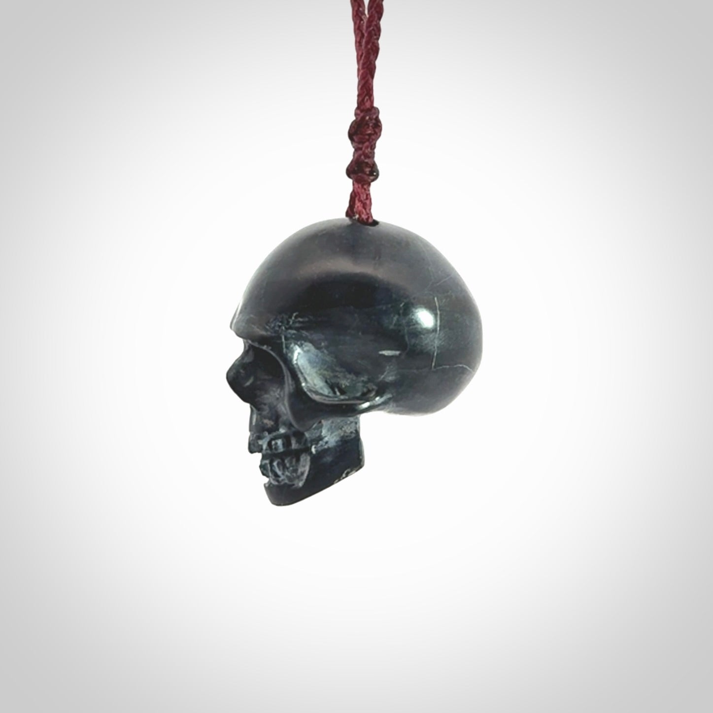 This picture shows a Black Obsidian stone skull pendant that we have hand carved. It is polished to a soft shine and is a very striking piece. Provided with an adjustable plum cord.
