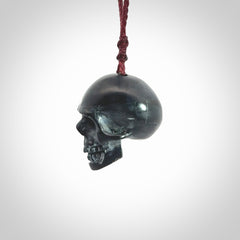 This picture shows a Black Obsidian stone skull pendant that we have hand carved. It is polished to a soft shine and is a very striking piece. Provided with an adjustable plum cord.