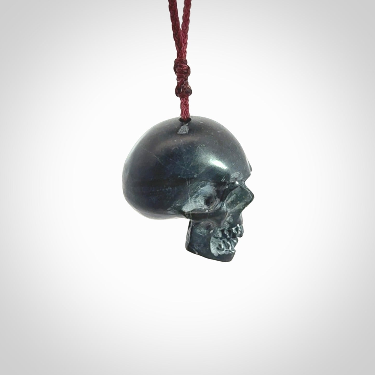 This picture shows a Black Obsidian stone skull pendant that we have hand carved. It is polished to a soft shine and is a very striking piece. Provided with an adjustable plum cord.