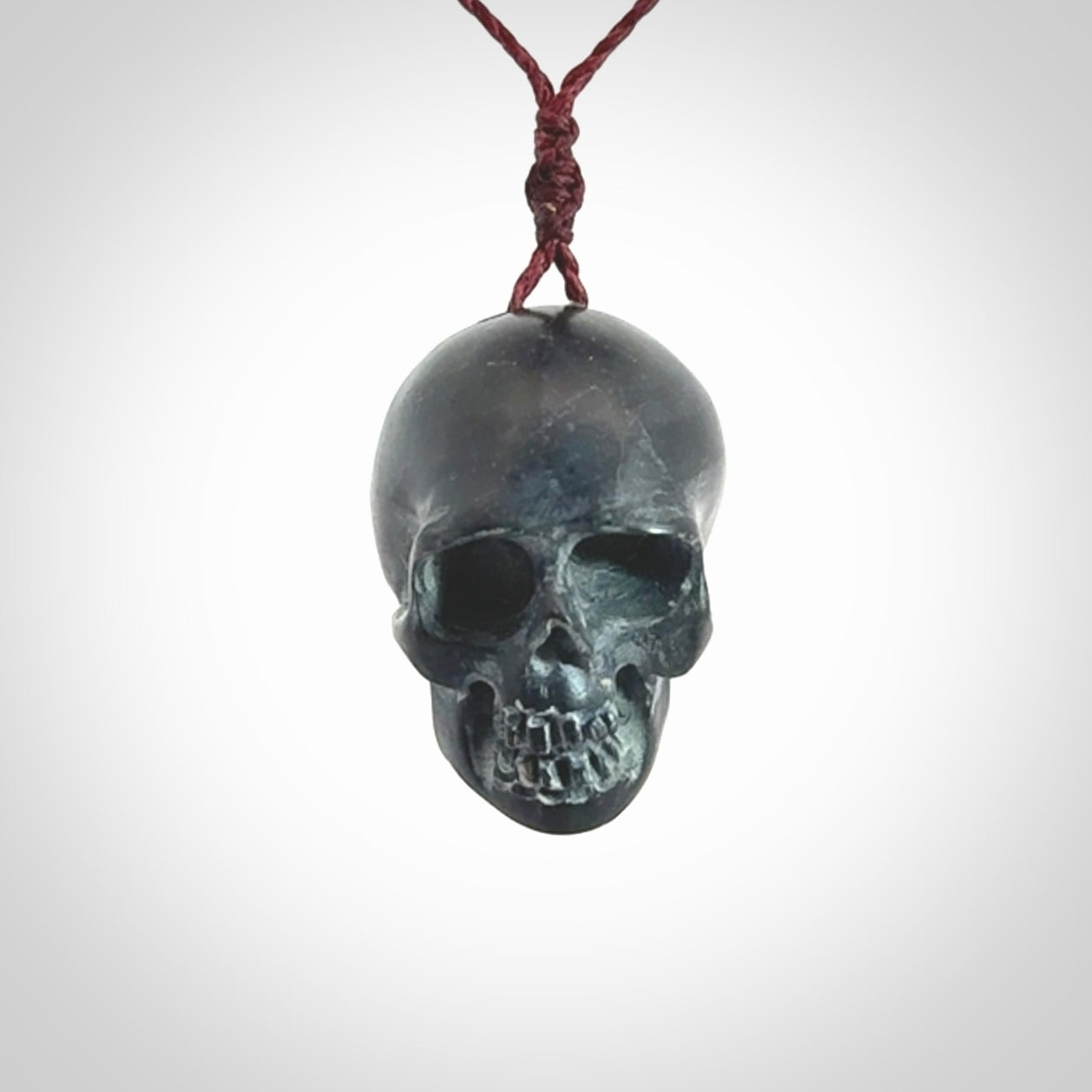 This picture shows a Black Obsidian stone skull pendant that we have hand carved. It is polished to a soft shine and is a very striking piece. Provided with an adjustable plum cord.