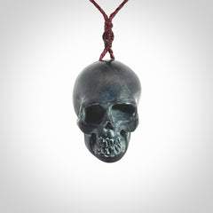 This picture shows a Black Obsidian stone skull pendant that we have hand carved. It is polished to a soft shine and is a very striking piece. Provided with an adjustable plum cord.