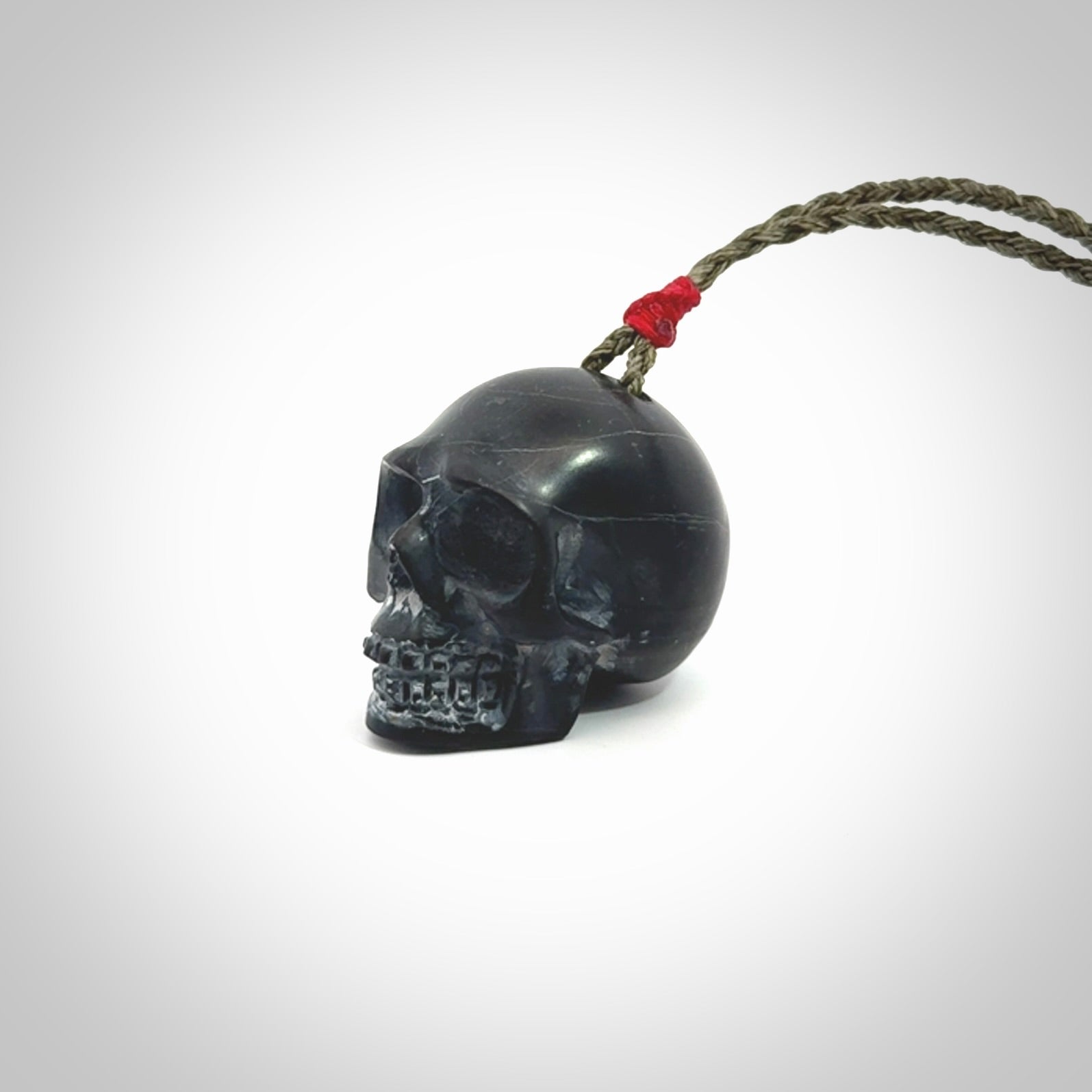 This picture shows a large Black Obsidian stone skull pendant that we have hand carved. It is polished to a soft shine and is a very striking piece. Provided with an adjustable khaki cord.