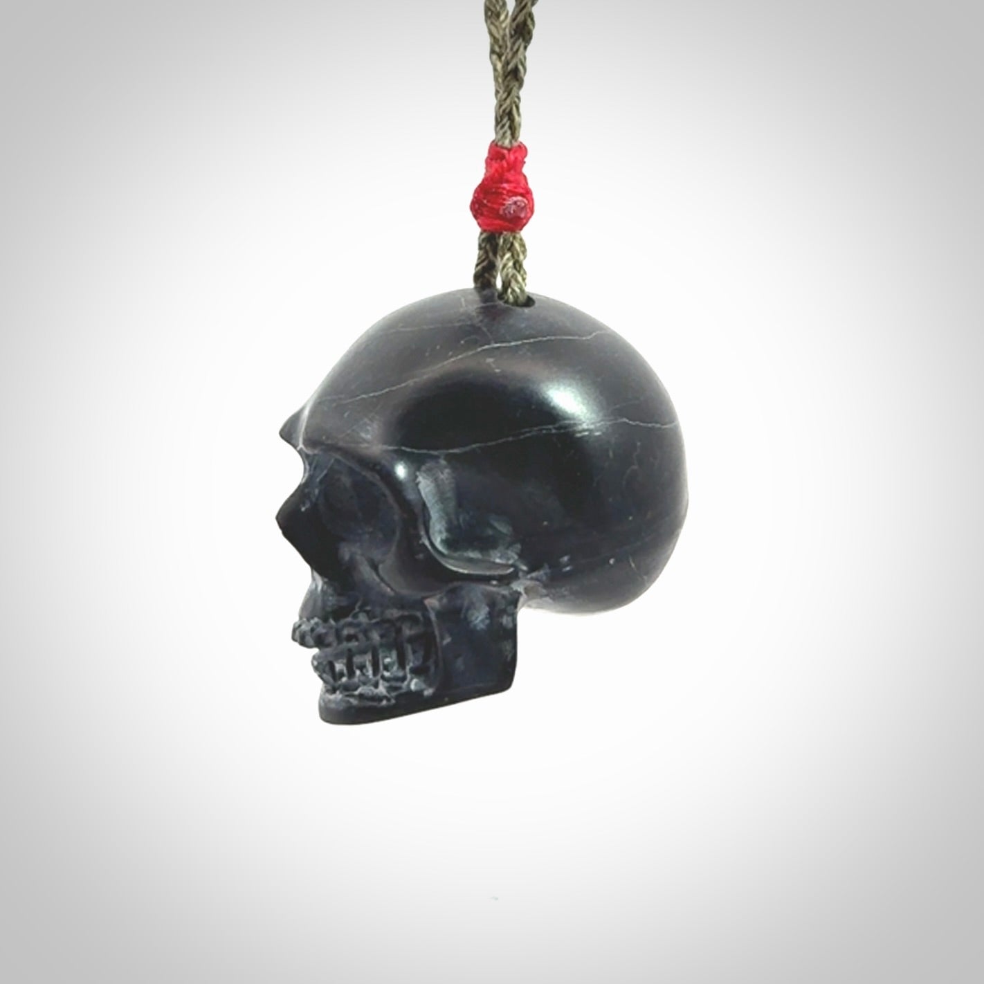 This picture shows a large Black Obsidian stone skull pendant that we have hand carved. It is polished to a soft shine and is a very striking piece. Provided with an adjustable khaki cord.