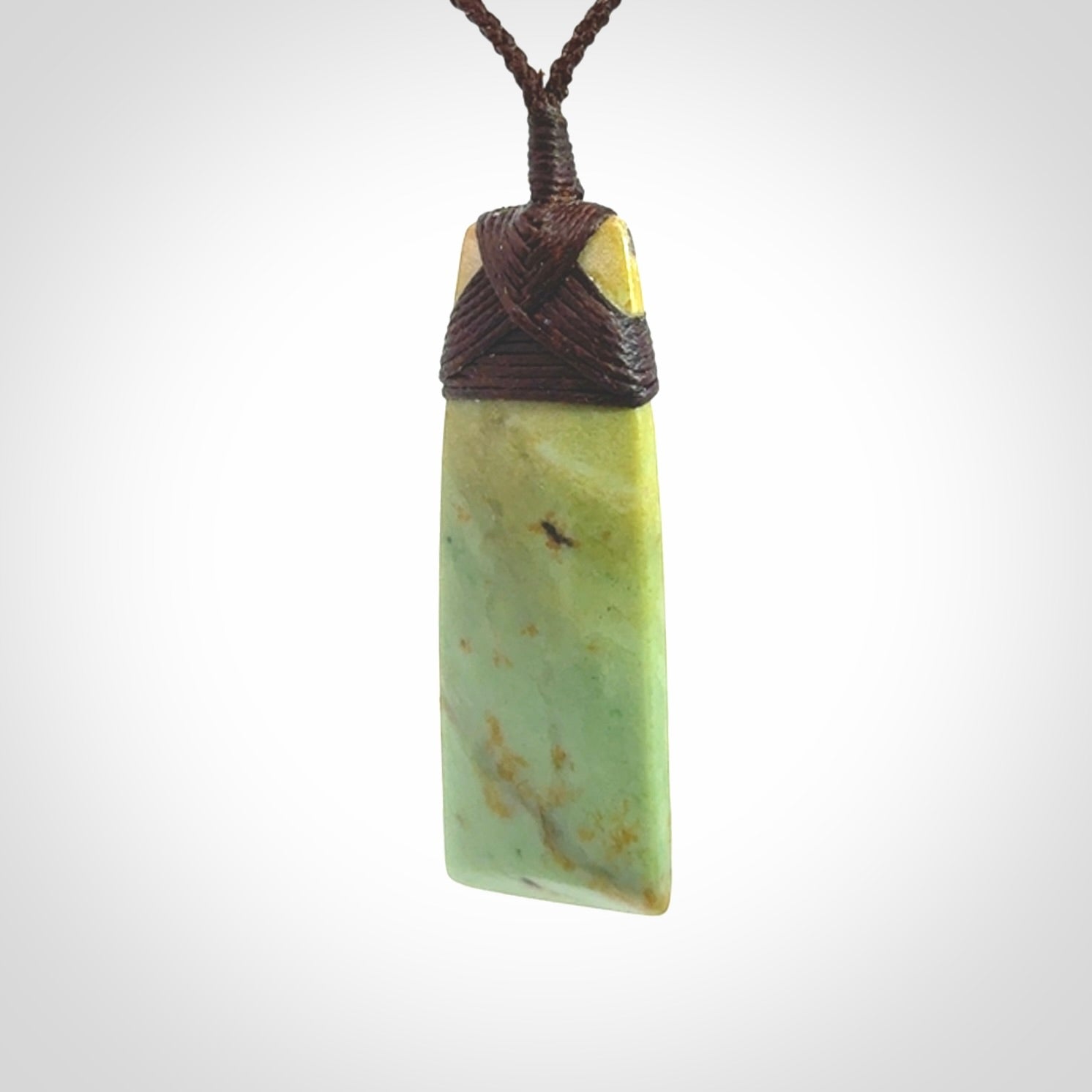 Hand carved from a lovely piece of local New Zealand flower Jade. We have suspended this from a 4-plait brown cord which can be adjusted with a couple of slip knots and brown binding.