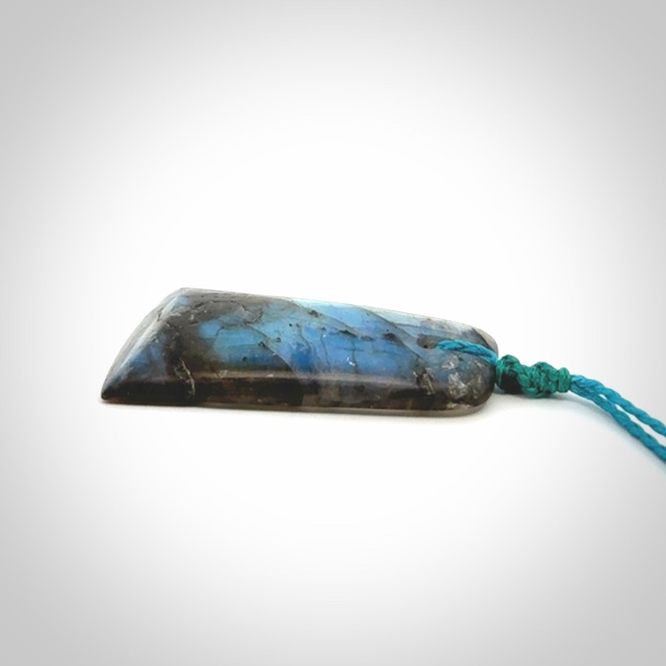 This picture shows a Labradorite stone toki pendant that we have hand carved.