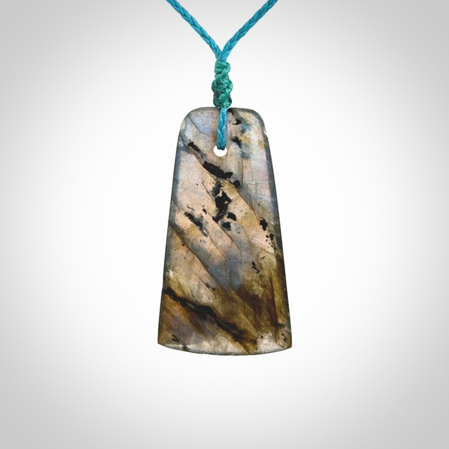 This picture shows a Labradorite stone toki pendant that we have hand carved.