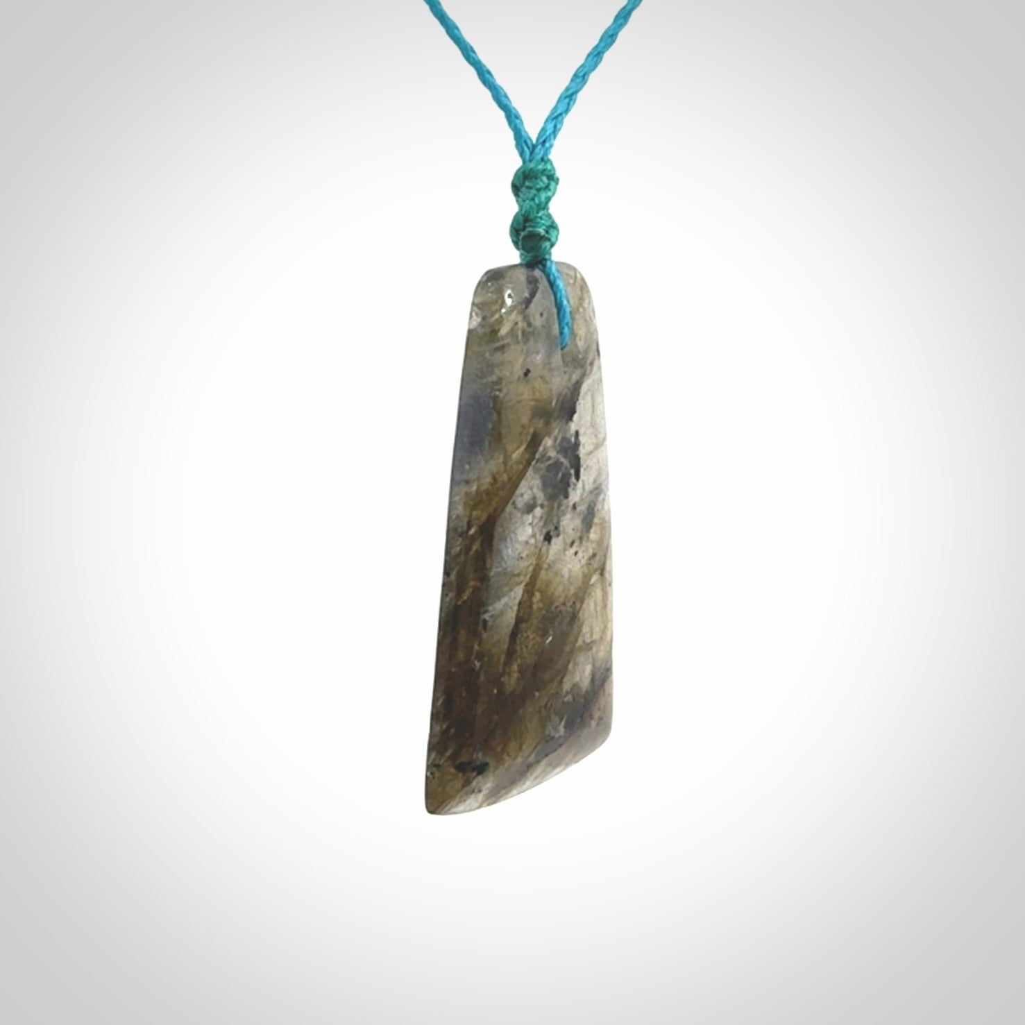 This picture shows a Labradorite stone toki pendant that we have hand carved.
