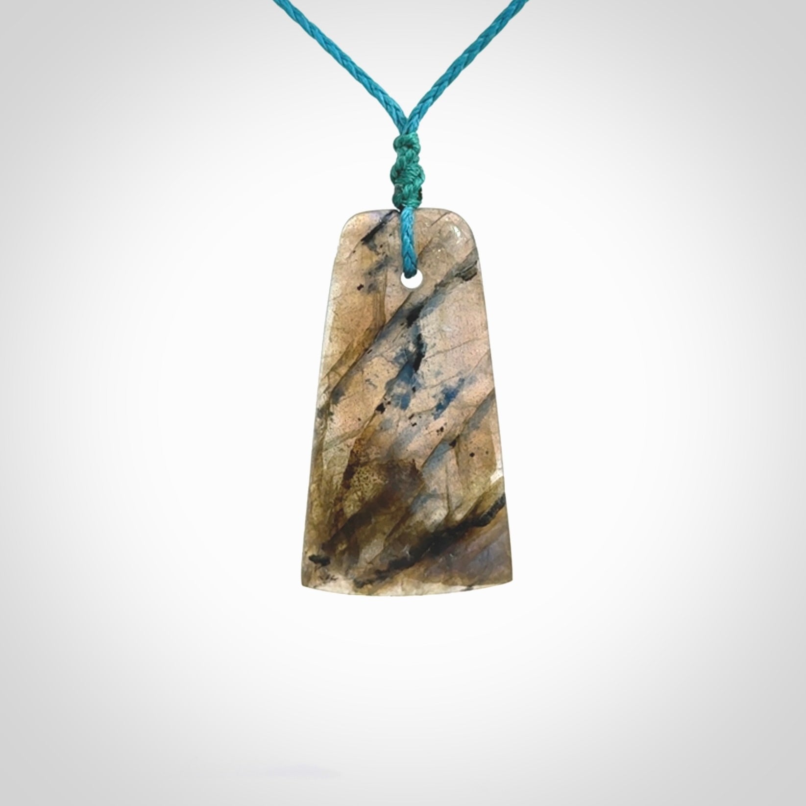 This picture shows a Labradorite stone toki pendant that we have hand carved.