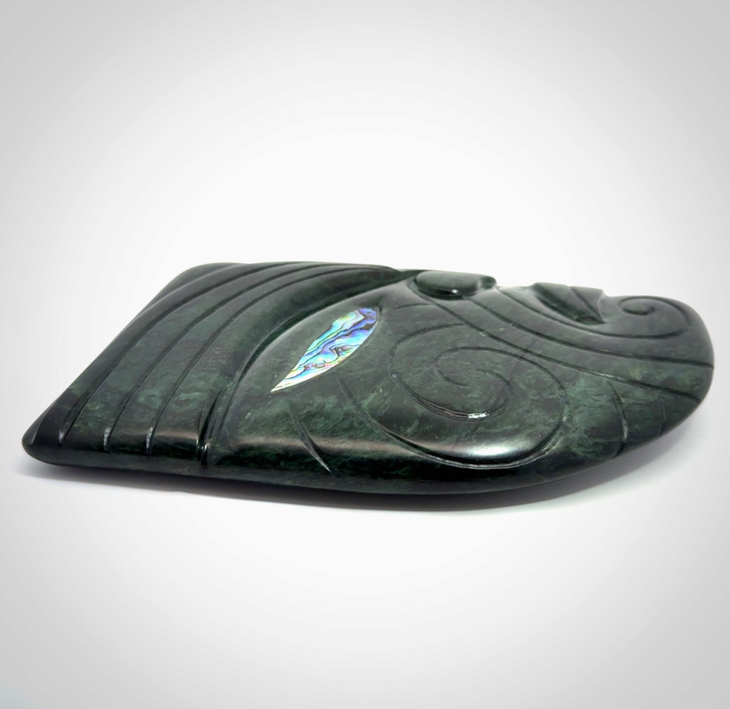 This is a large hand carved New Zealand Jade chief head display art. It is made from New Zealand Jade and Paua shell.