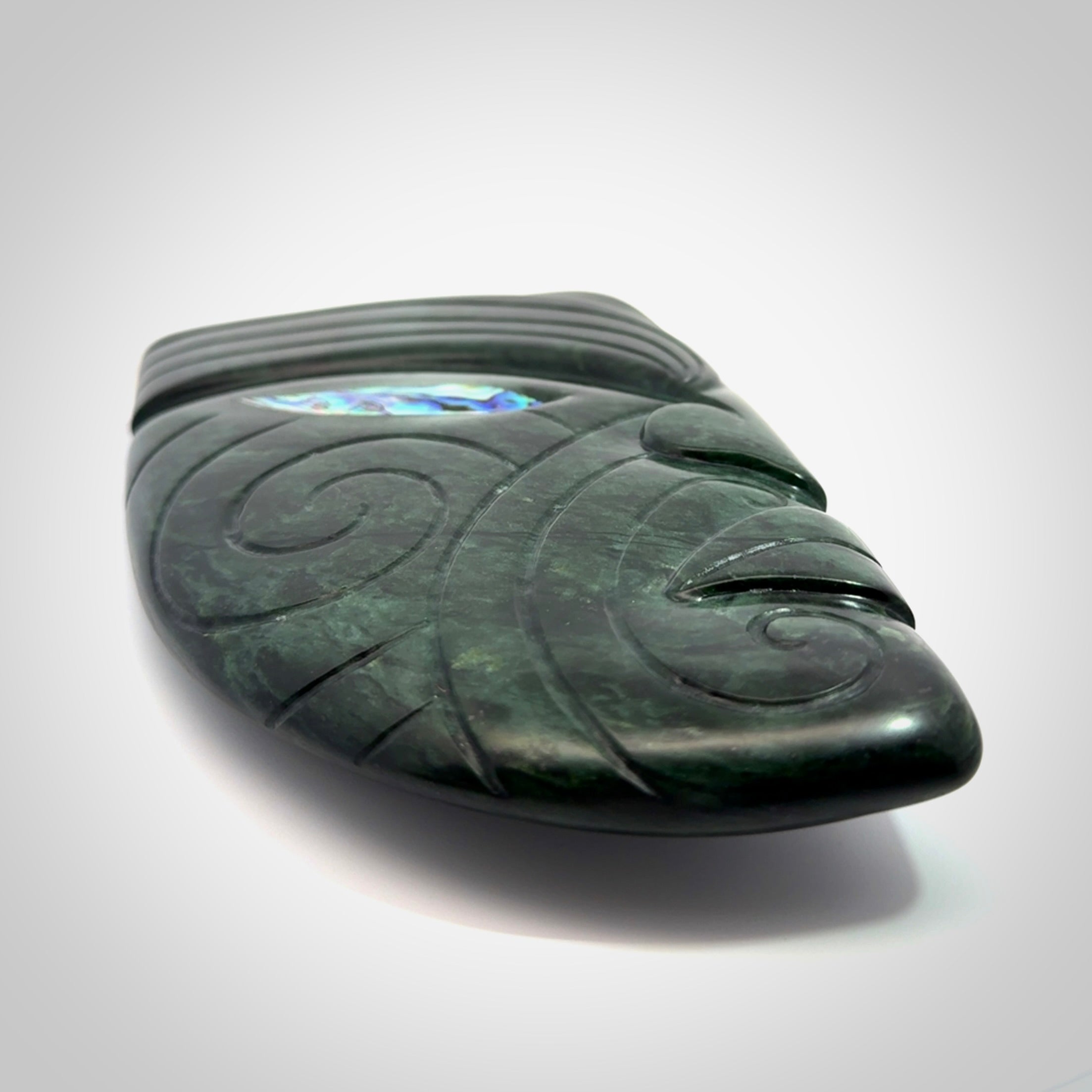 This is a large hand carved New Zealand Jade chief head display art. It is made from New Zealand Jade and Paua shell.