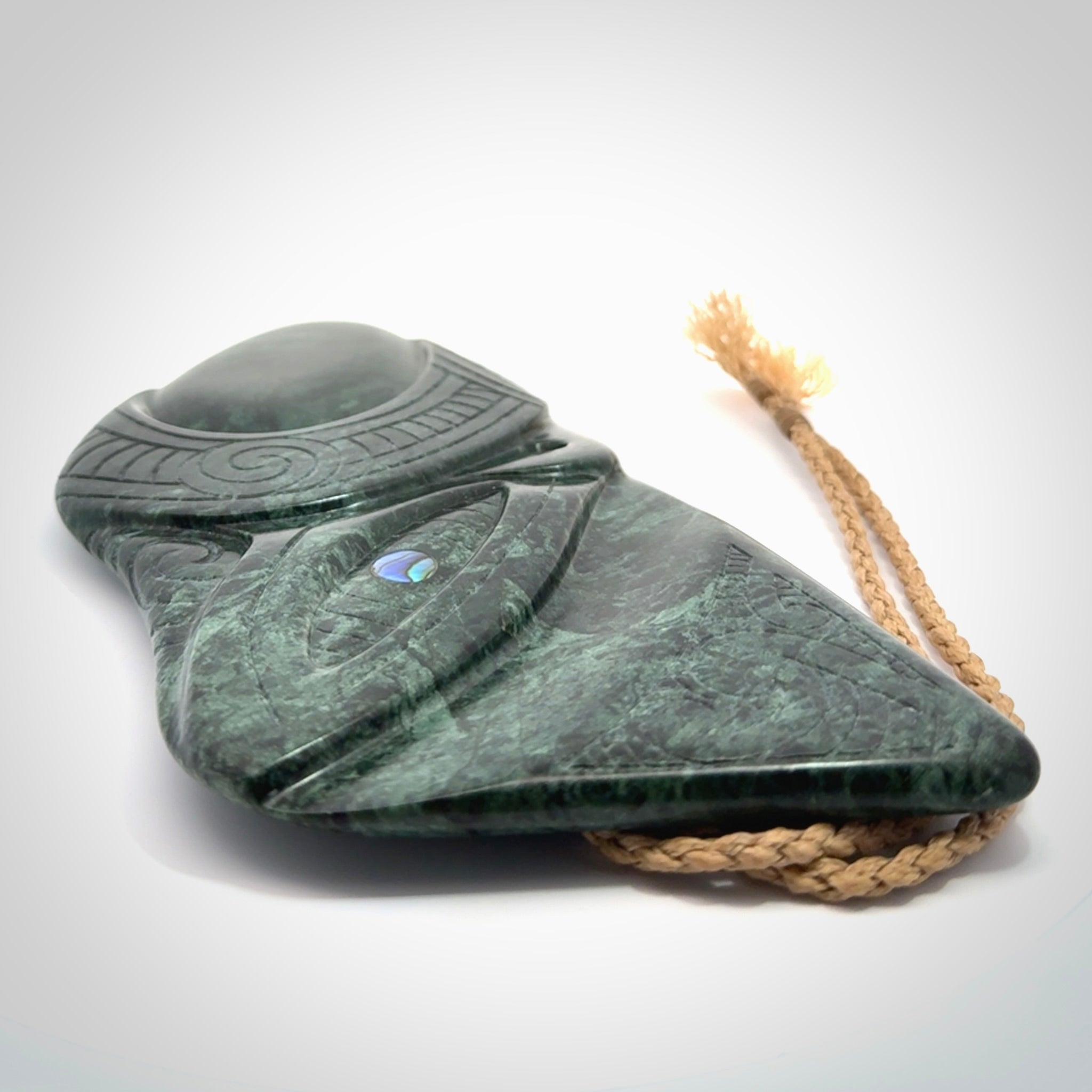 This is a large hand carved New Zealand Jade wheku pendant. It is made from New Zealand Jade and Paua shell.
