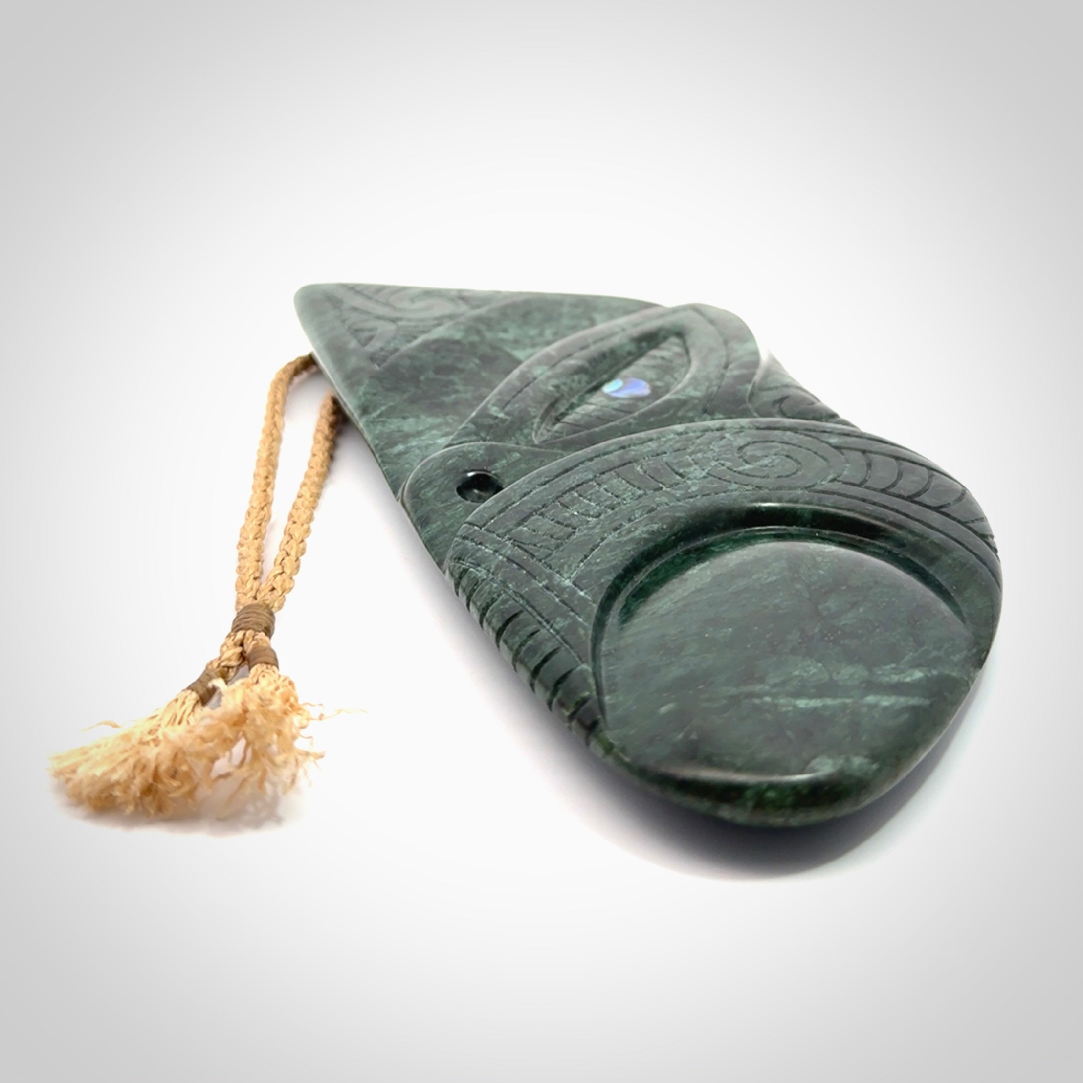 This is a large hand carved New Zealand Jade wheku pendant. It is made from New Zealand Jade and Paua shell.