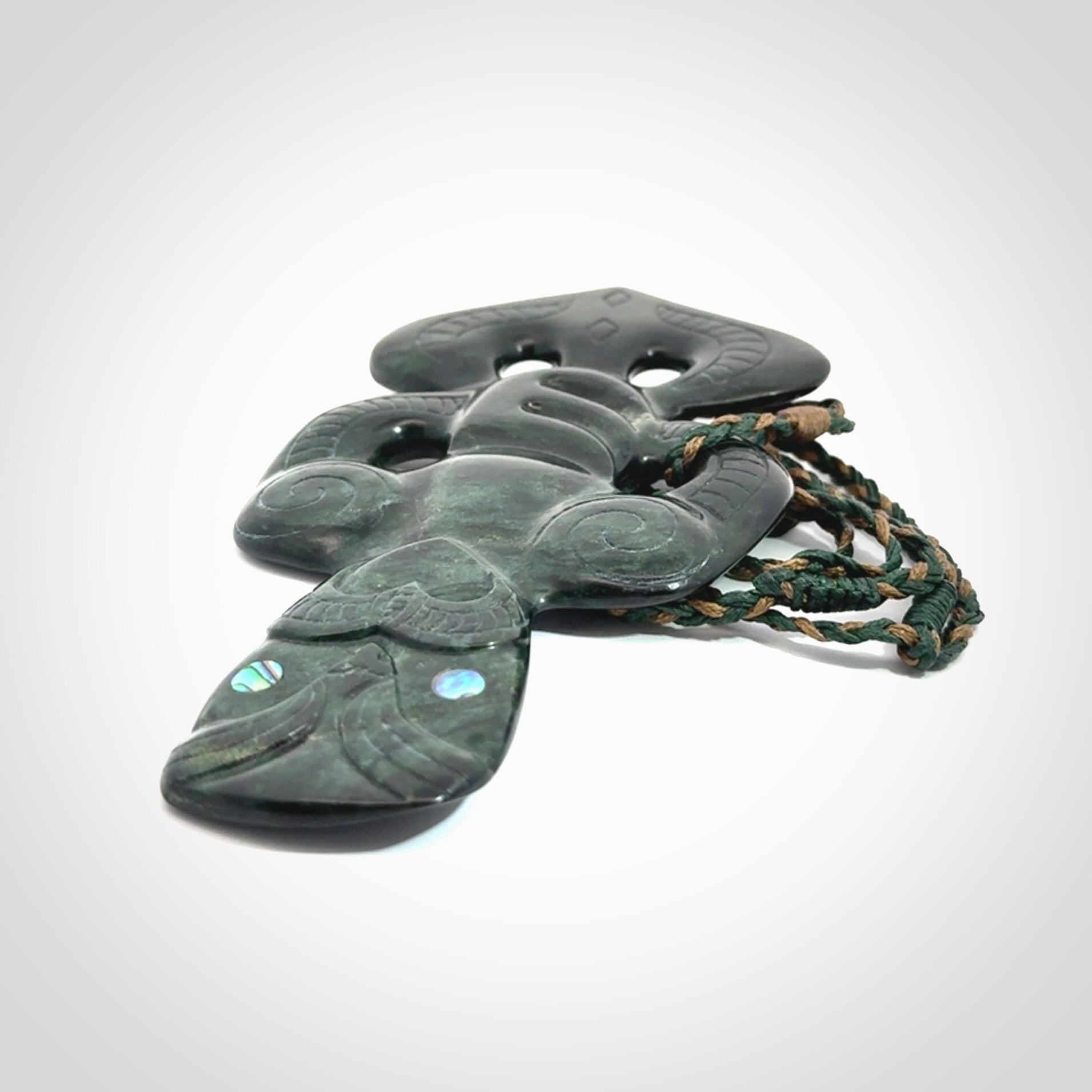 This is a large hand carved New Zealand Jade tiki pendant. It is made from New Zealand Jade and Paua shell.