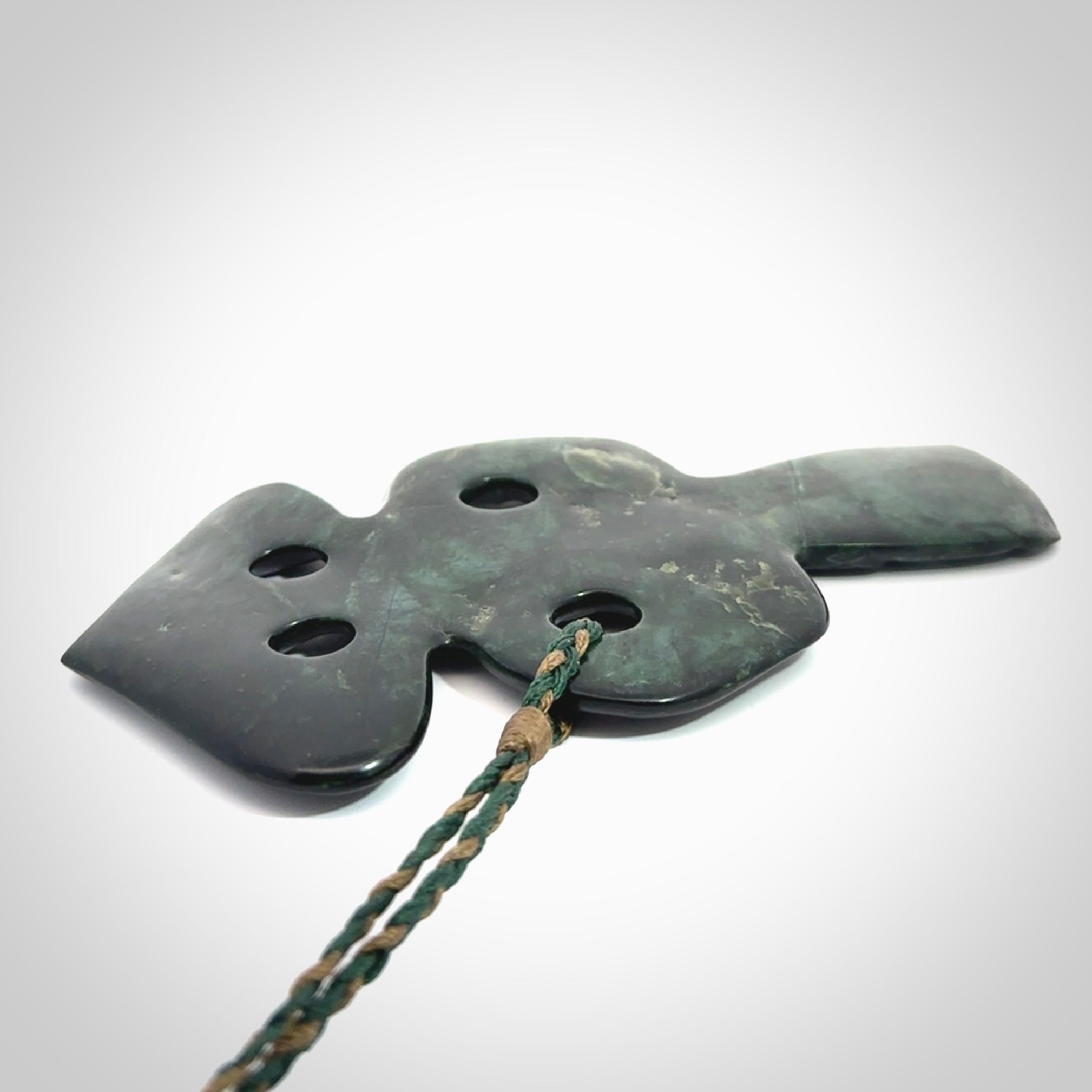 This is a large hand carved New Zealand Jade tiki pendant. It is made from New Zealand Jade and Paua shell.