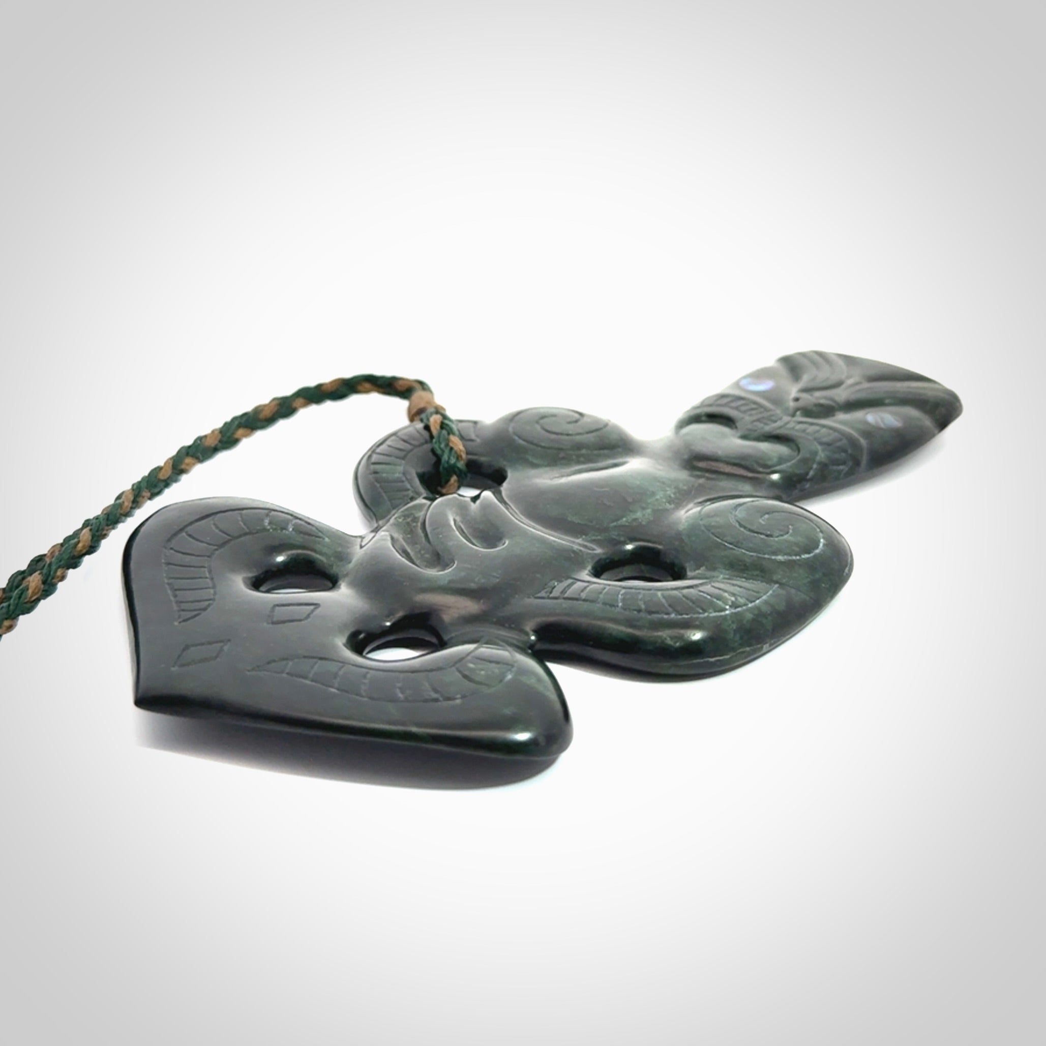 This is a large hand carved New Zealand Jade tiki pendant. It is made from New Zealand Jade and Paua shell.