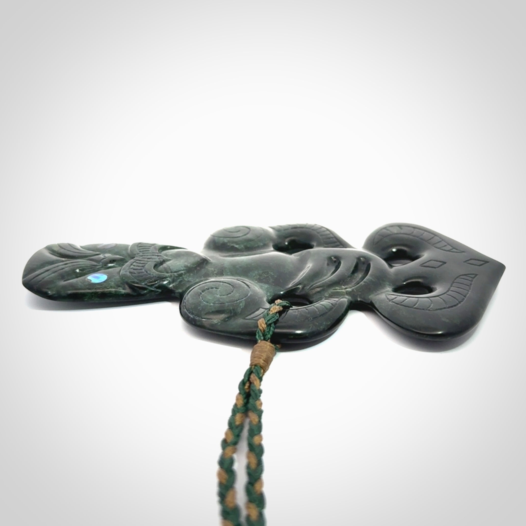 This is a large hand carved New Zealand Jade tiki pendant. It is made from New Zealand Jade and Paua shell.