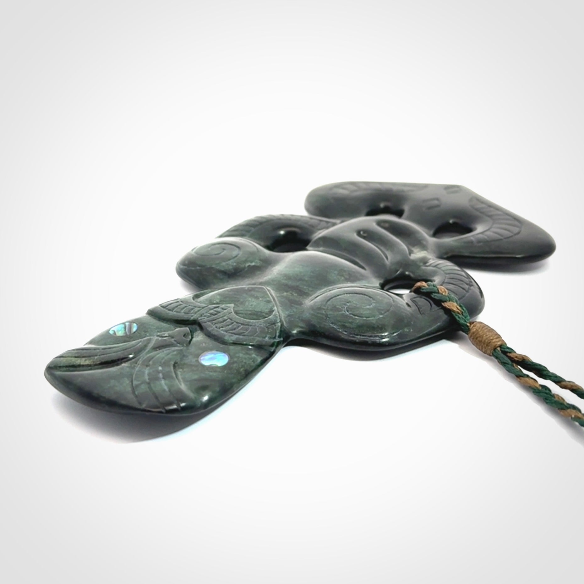 This is a large hand carved New Zealand Jade tiki pendant. It is made from New Zealand Jade and Paua shell.