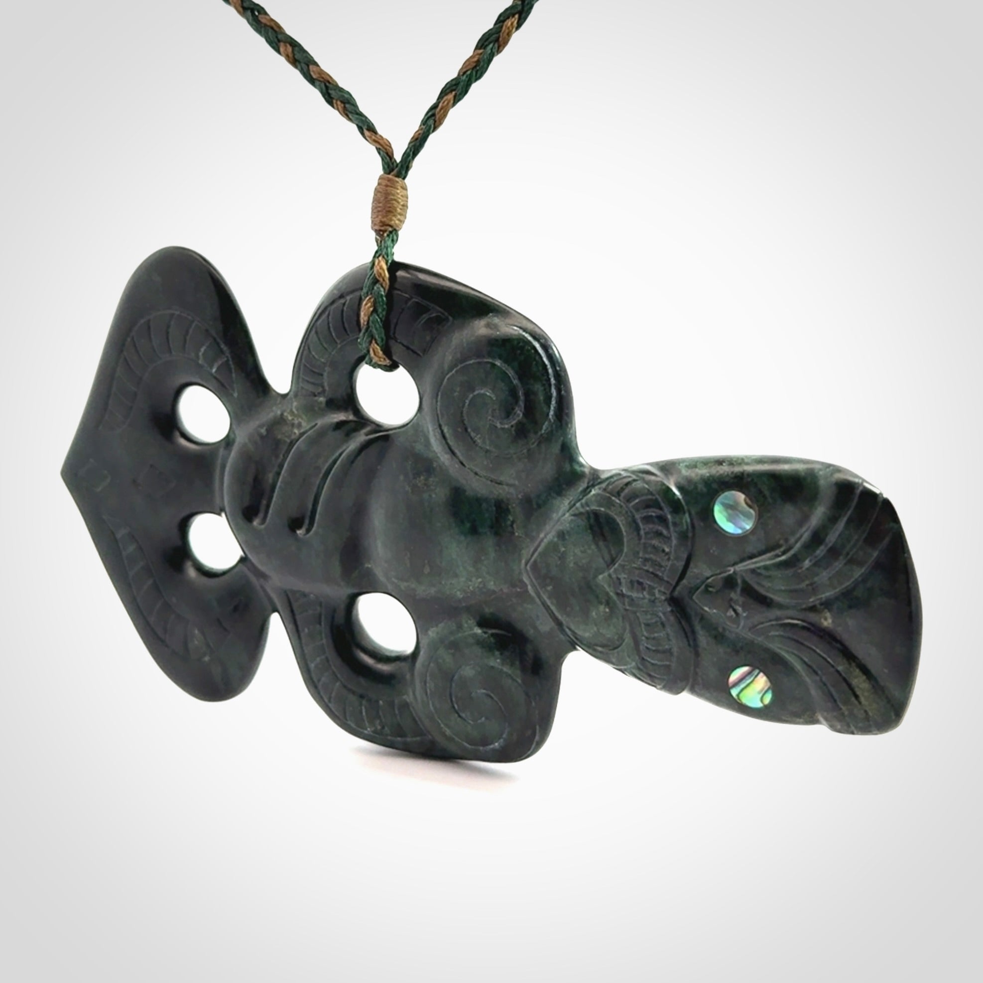 This is a large hand carved New Zealand Jade tiki pendant. It is made from New Zealand Jade and Paua shell.
