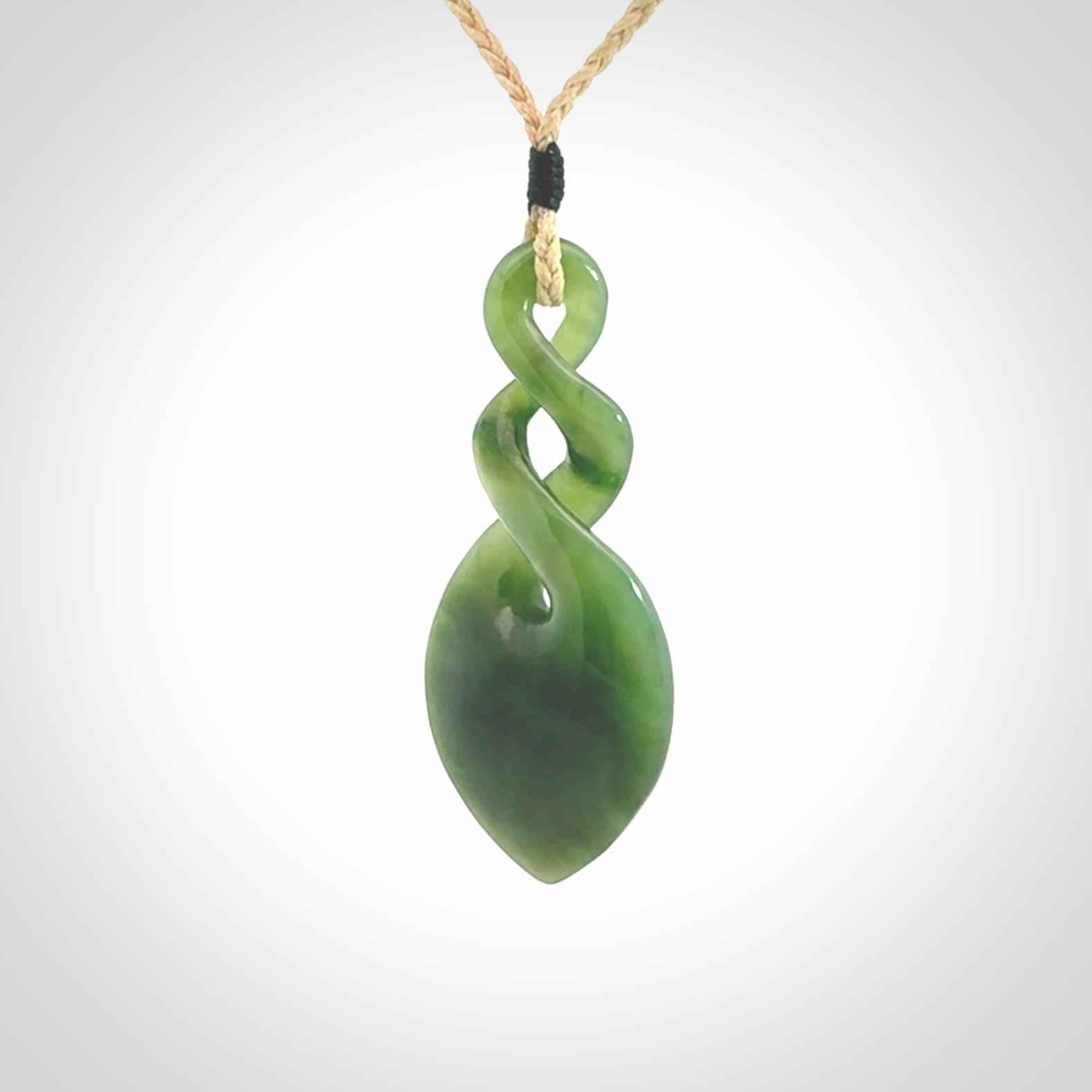 Hand carved New Zealand jade twist pendant. Carved in New Zealand by NZ Pacific. Unique double twist jewellery for sale online. Provided with an adjustable oat cord.