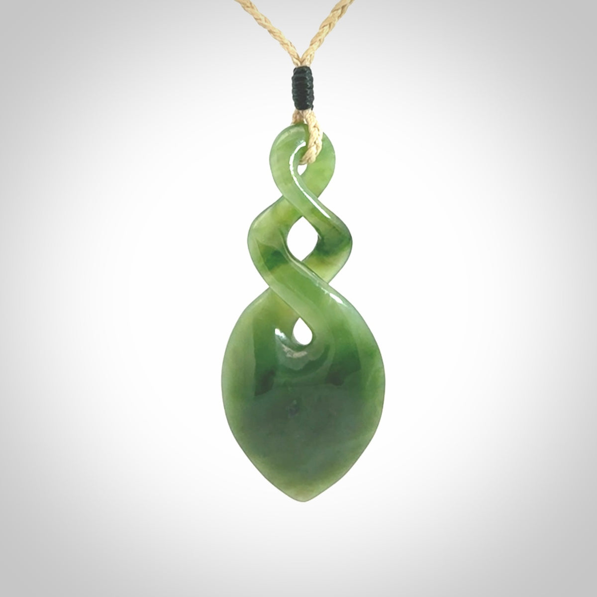 Hand carved New Zealand jade twist pendant. Carved in New Zealand by NZ Pacific. Unique double twist jewellery for sale online. Provided with an adjustable oat cord.