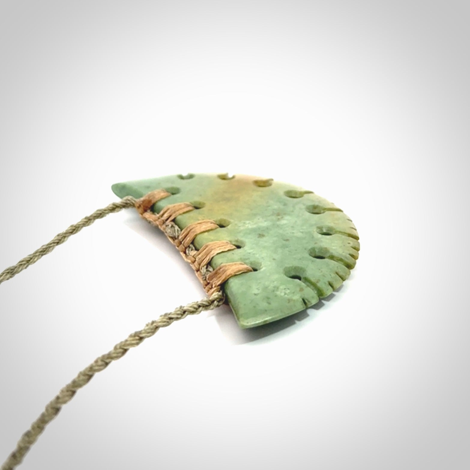 Hand carved New Zealand Flower Jade half-shield pendant.