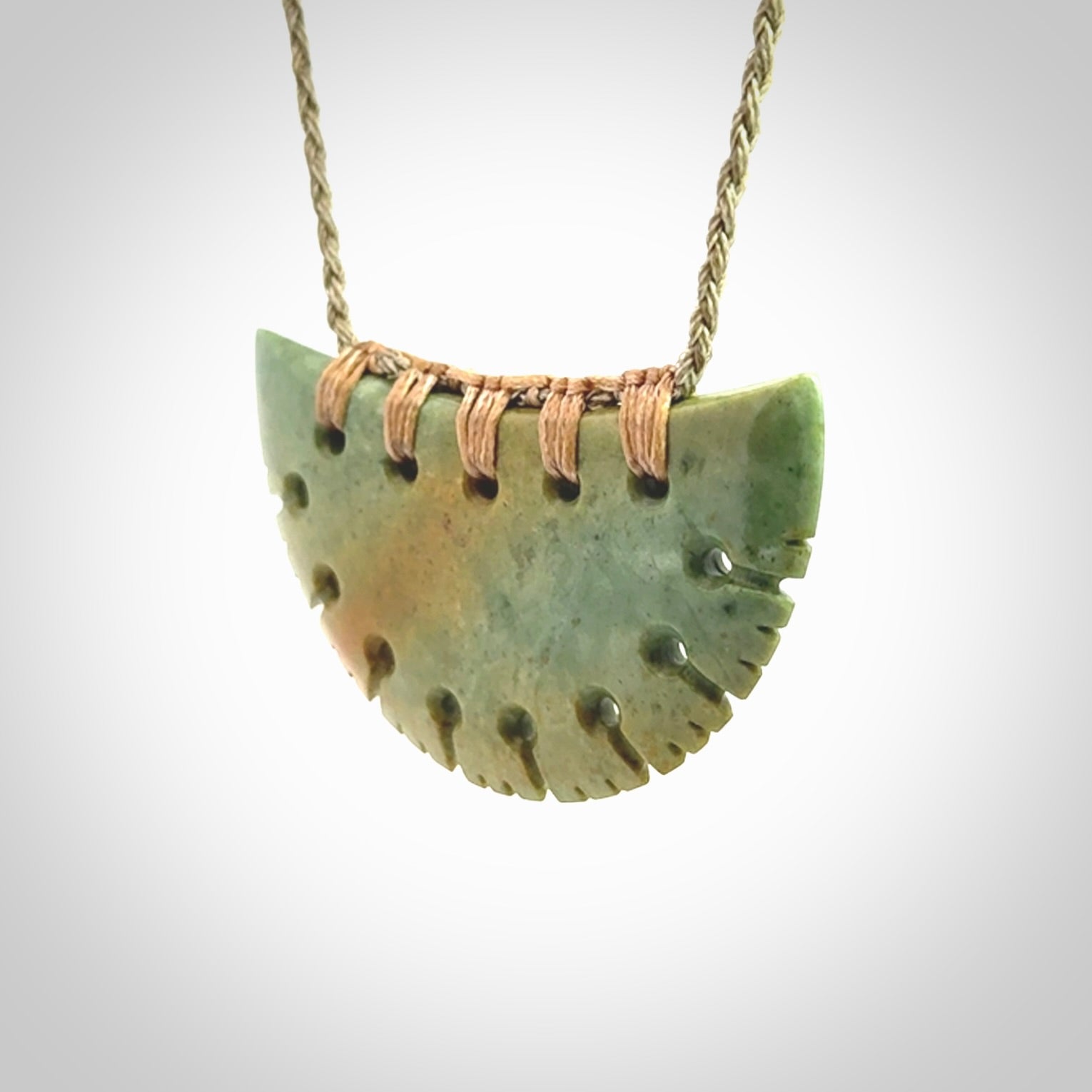 Hand carved New Zealand Flower Jade half-shield pendant.