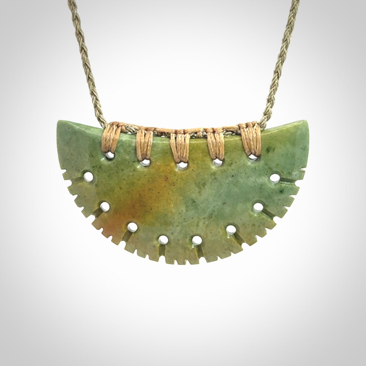 Hand carved New Zealand Flower Jade half-shield pendant.