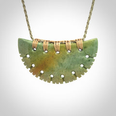 Hand carved New Zealand Flower Jade half-shield pendant.