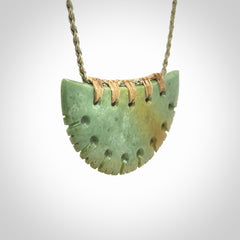 Hand carved New Zealand Flower Jade half-shield pendant.