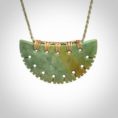 Hand carved New Zealand Flower Jade half-shield pendant.